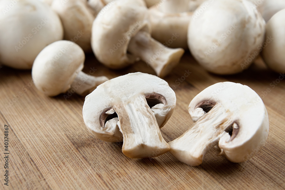 Fresh sliced mushrooms at wooden cutting board Fresh sliced mushrooms at wooden cutting board