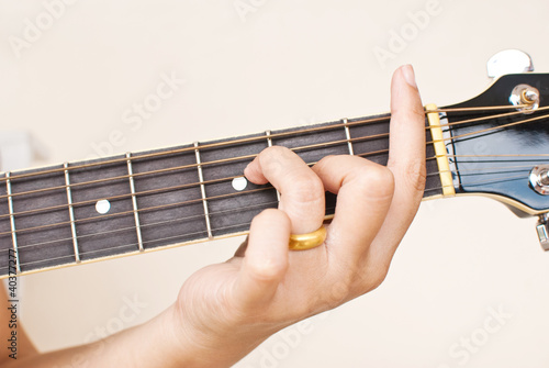 Hand pressing classic acoustic guitar chord. photo