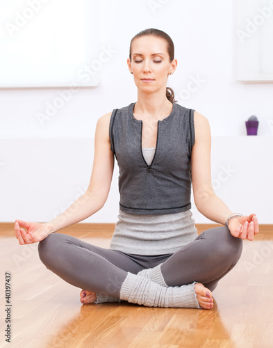 Woman doing stretching yoga exercise at sport gym