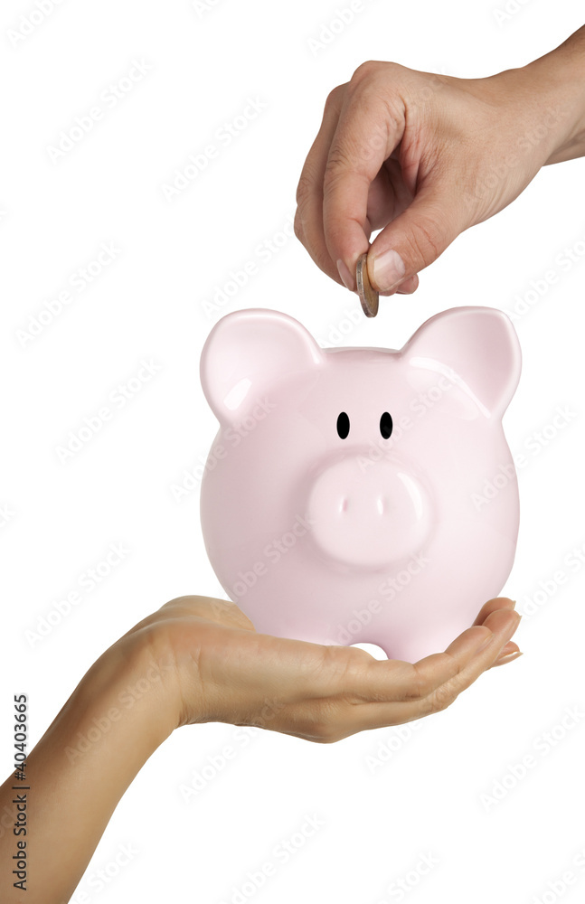 Male hand putting coin into a piggy bank isolated on white