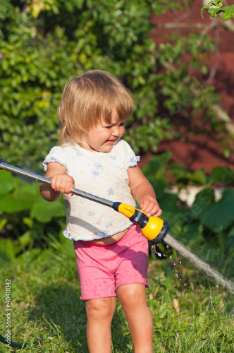 little girl in garden are pouring to water