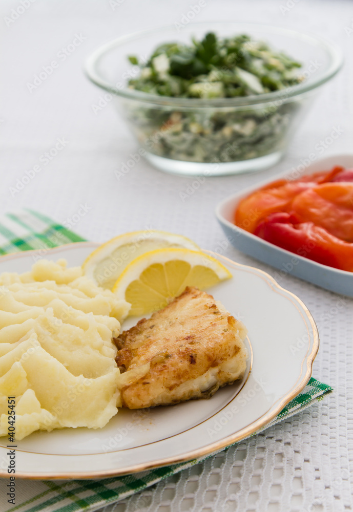Roast fish steak with mashed potatoes and salad. Roast fish steak with mashed potatoes and salad.