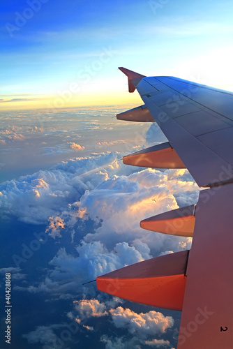 View of jet plane wing with cloud patterns