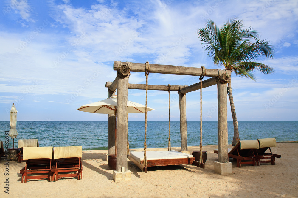 Beach beds among palm trees at perfect tropical coast Beach beds among palm trees at perfect tropical coast