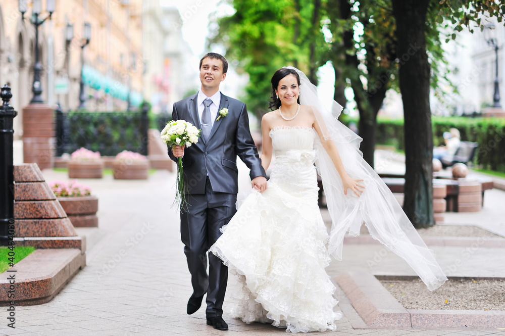 Naklejka premium Bride and groom having fun in an old town