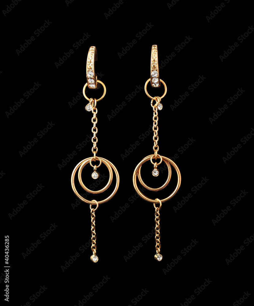 gold earrings over black background gold earrings over black background