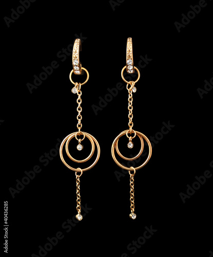 gold earrings over black background