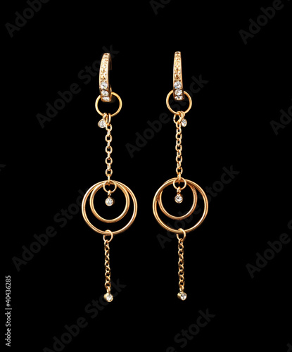 gold earrings over black background © zea_lenanet