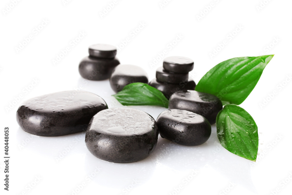 Spa stones with drops and green leaves isolated on white Spa stones with drops and green leaves isolated on white