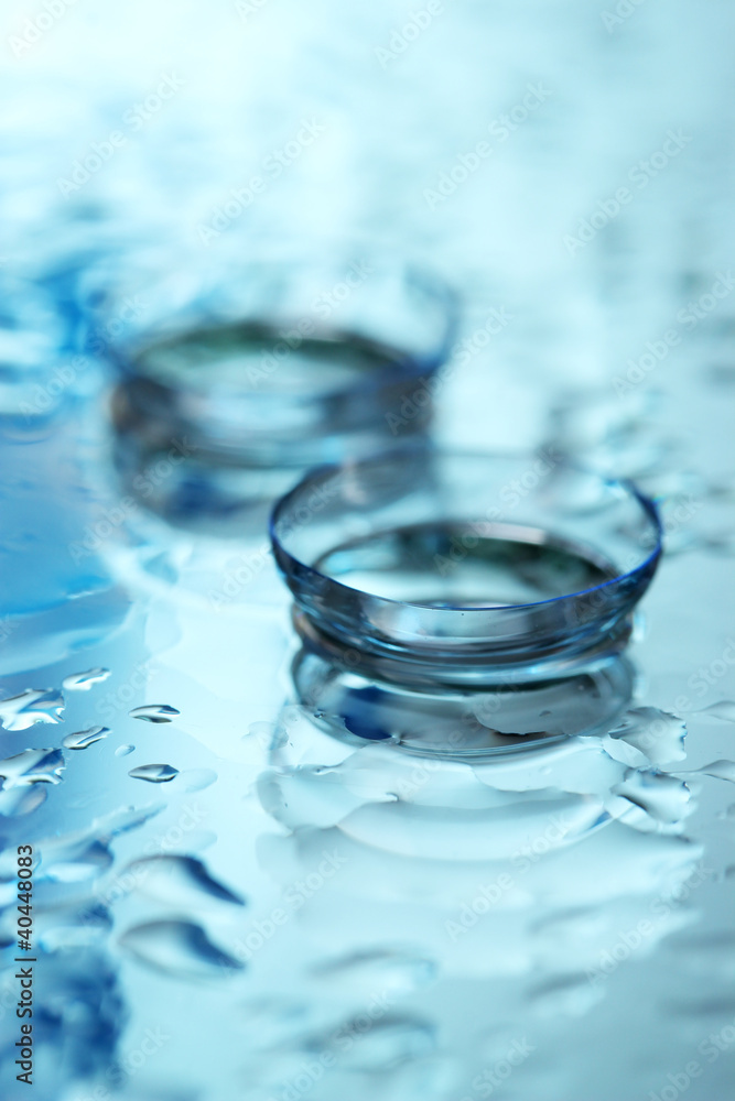contact lens with drops on blue background contact lens with drops on blue background