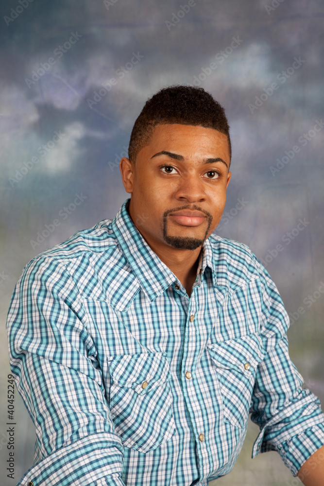 Black man looking at the camera with a thoughtful with a smile Black man looking at the camera with a thoughtful with a smile