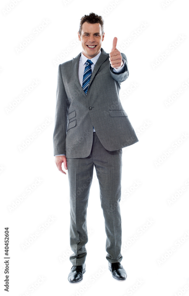 Confident businessman gesturing thumbs up