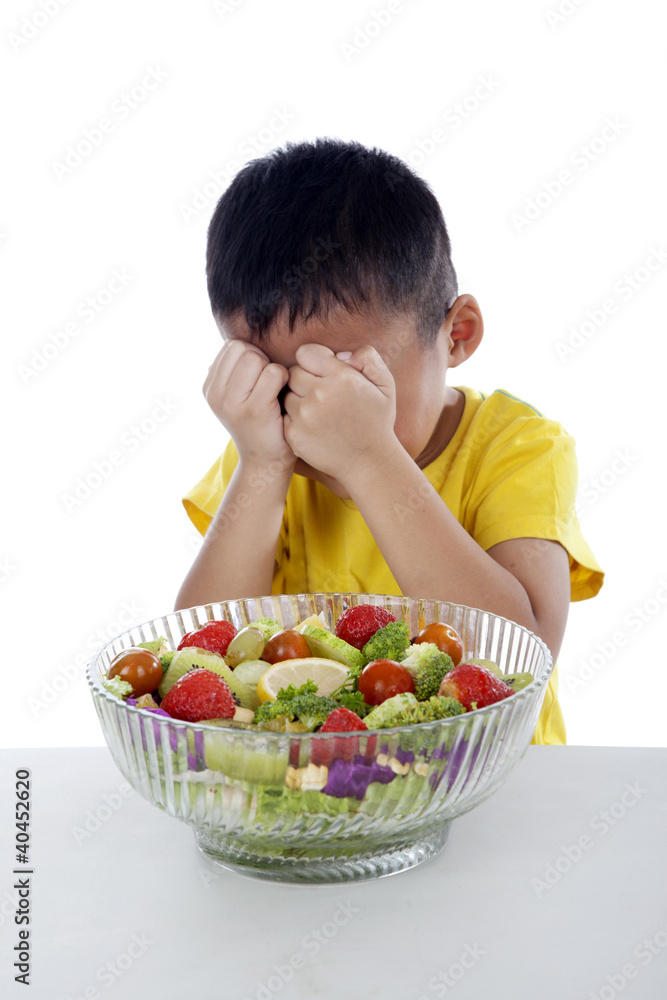 Crying boy with a bow of fruit salad Crying boy with a bow of fruit salad