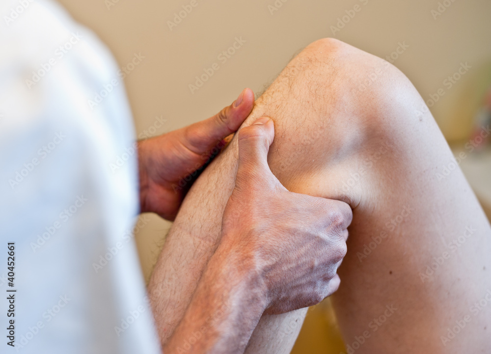 Naklejka premium Healing hands - Osteopathic treatment on patient's knee