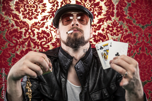 Gangster Looking Man Holding Poker Cards and His winnings