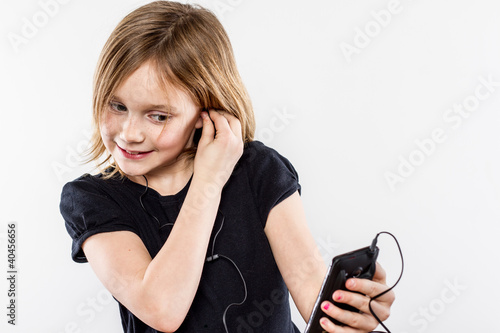 Young Girl Putting Headphones on Listening to an MP3 Device