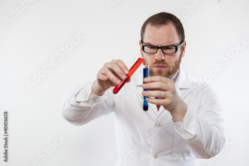 A male scientist mix two colored chemicals