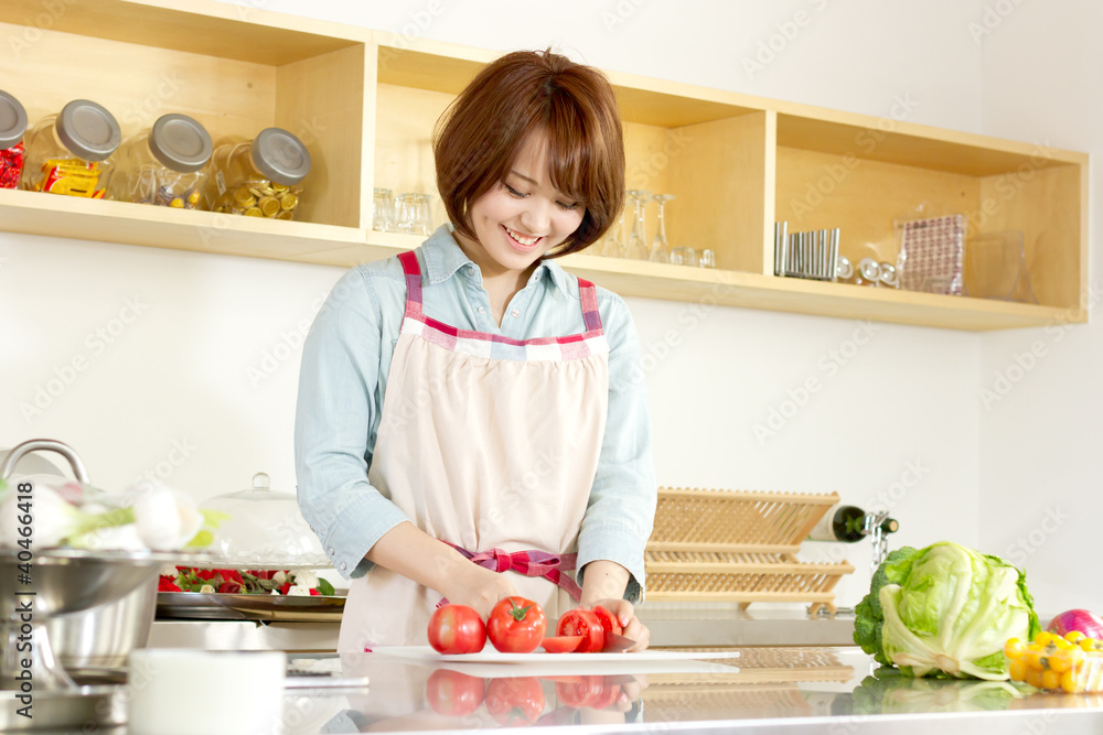 Beautiful young woman in kitchen making salad. Portrait of asian Beautiful young woman in kitchen making salad. Portrait of asian