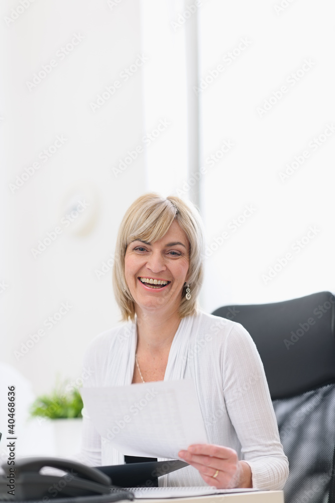 Happy mature business woman working at office Happy mature business woman working at office