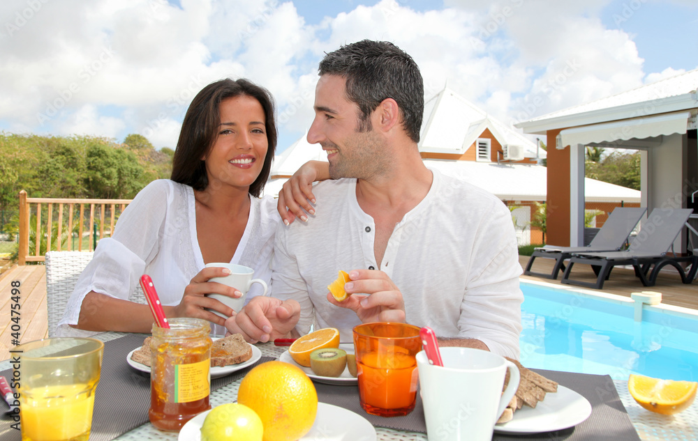Cheerful couple taking breakfast on the outdoor terrace Cheerful couple taking breakfast on the outdoor terrace