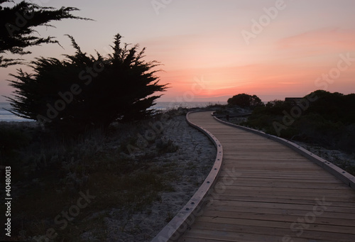 Sunset over a walkway through sand dunes at Asilomar State Park photo