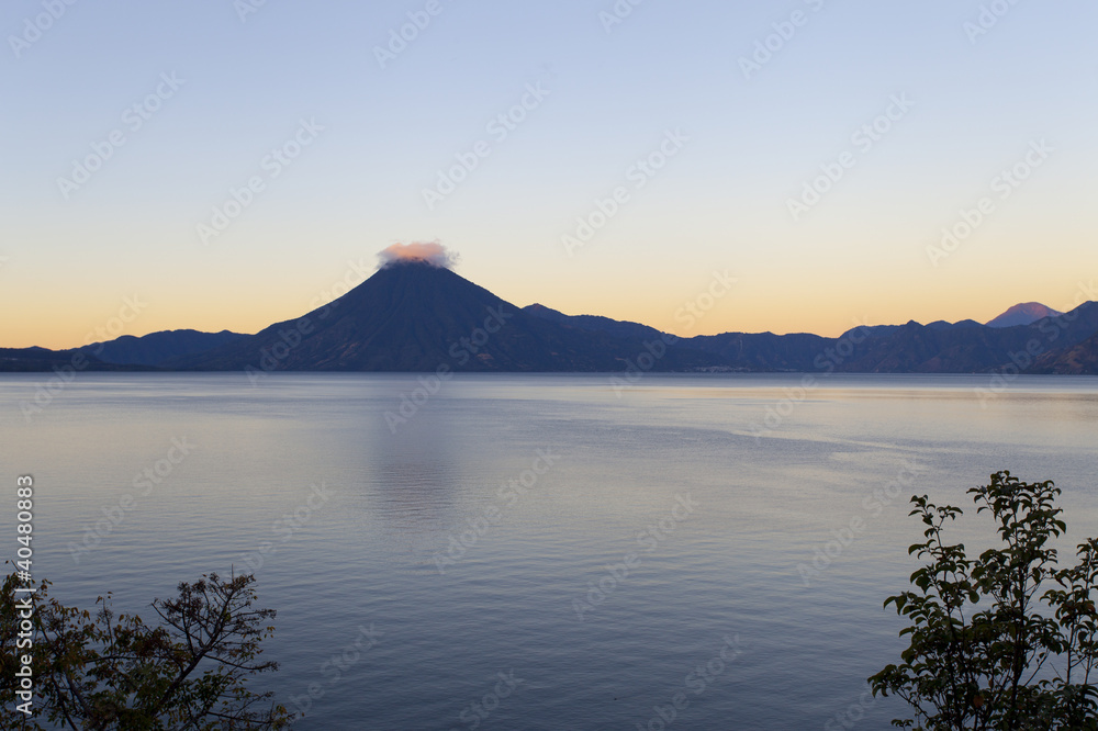 Vue zen sur lac et volcan nuageux
