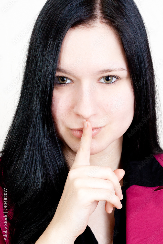 Black haired Girl holding her forefinger on her lips. Black haired Girl holding her forefinger on her lips.