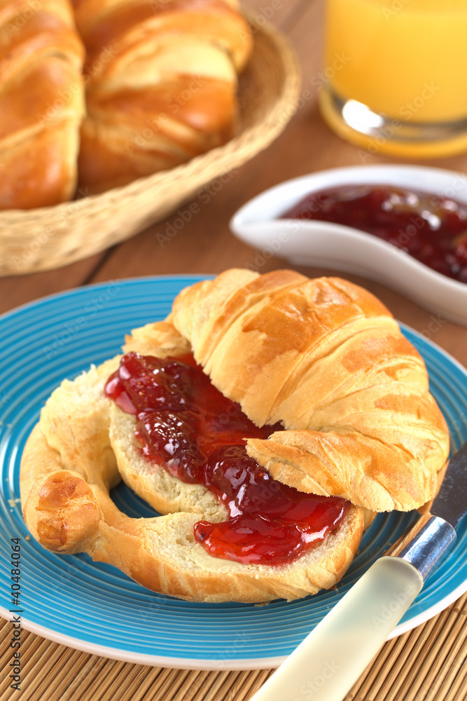 Croissant with butter and strawberry jam Croissant with butter and strawberry jam