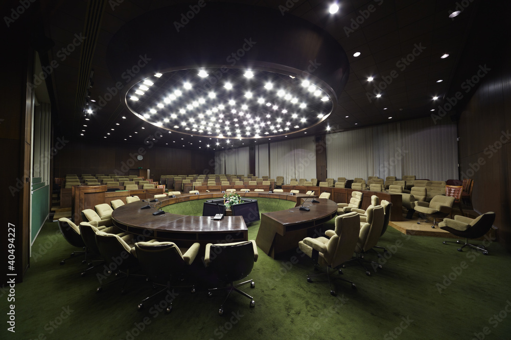 Fototapeta premium Auditorium with round oak table and beige armchairs