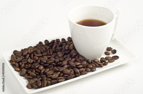 Cup of coffee and beans on white