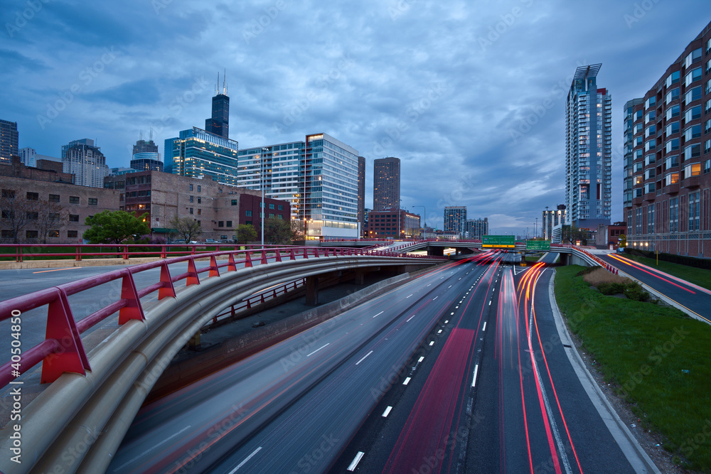 Obraz premium Ruchliwa autostrada miejska o zmierzchu w Chicago.