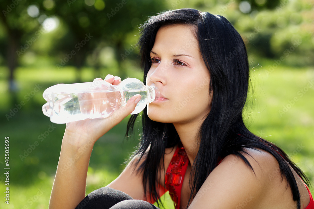 Portrait of young woman drinking water from the bottle Portrait of young woman drinking water from the bottle