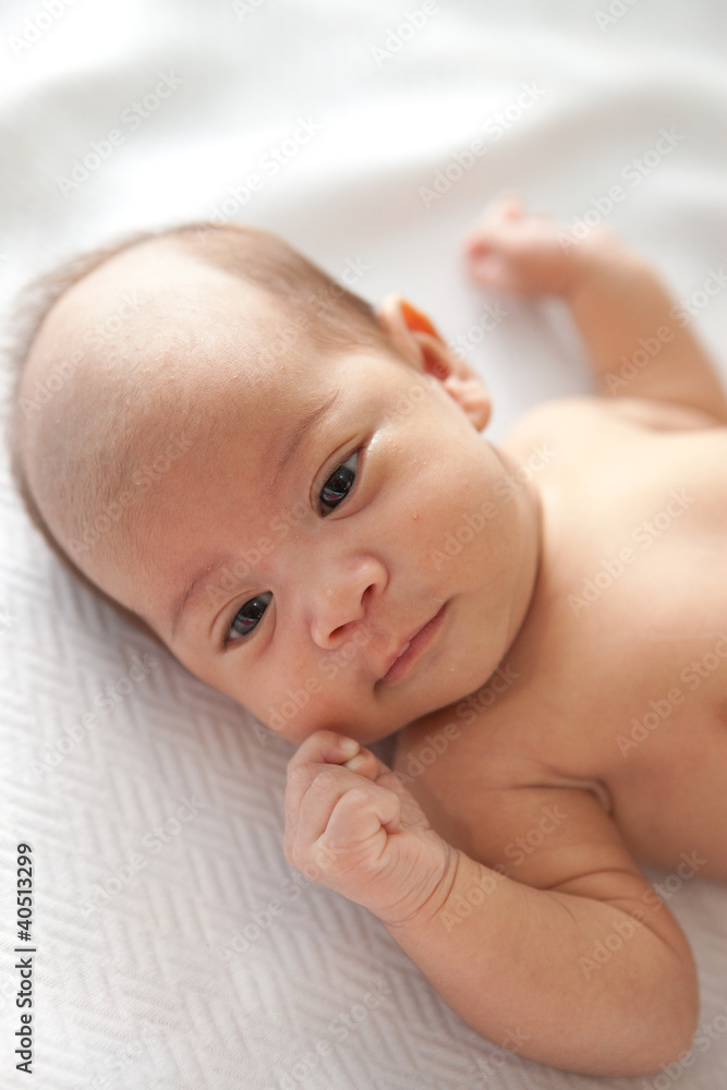 asia infant lying down on White colored blanket asia infant lying down on White colored blanket