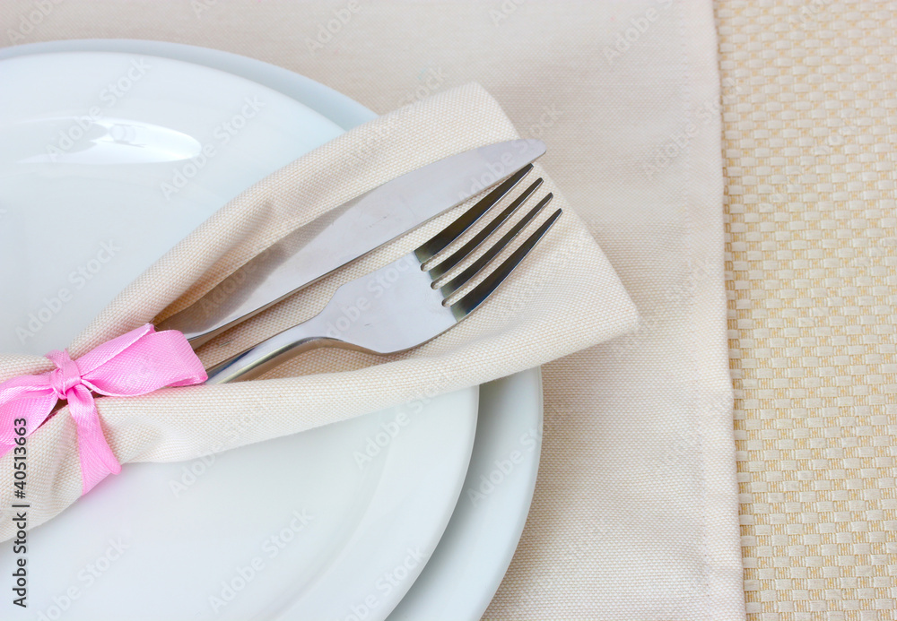 Table setting with fork, knife, plates, and napkin