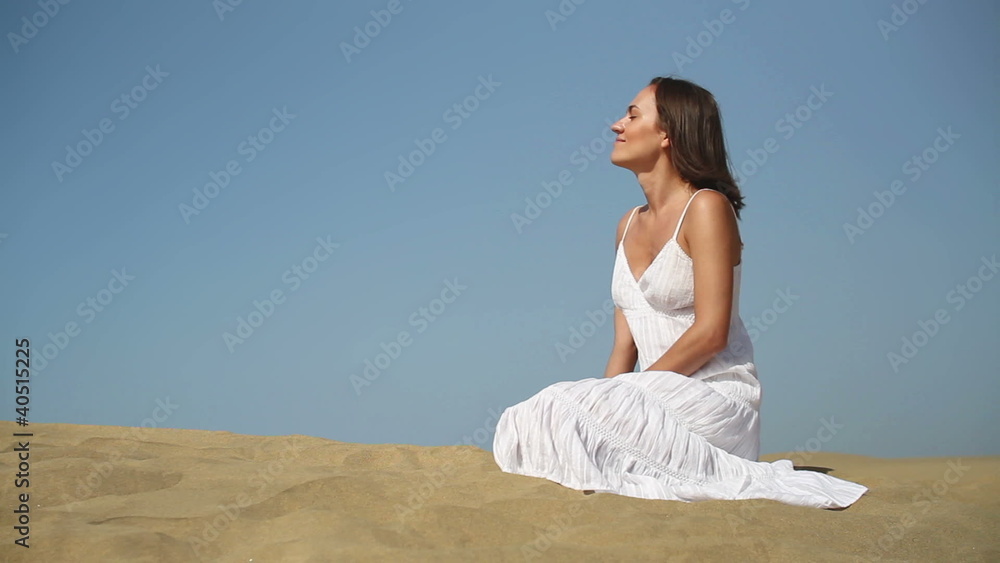Sexy woman in white dress sitting on the desert Sexy woman in white dress sitting on the desert