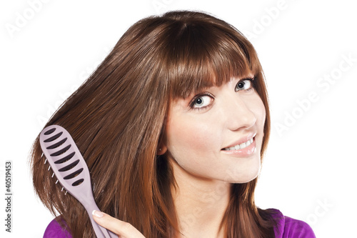 Brunette brushing her hair, in studio