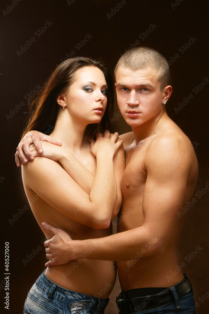 A loving couple embraces on brown background A loving couple embraces on brown background