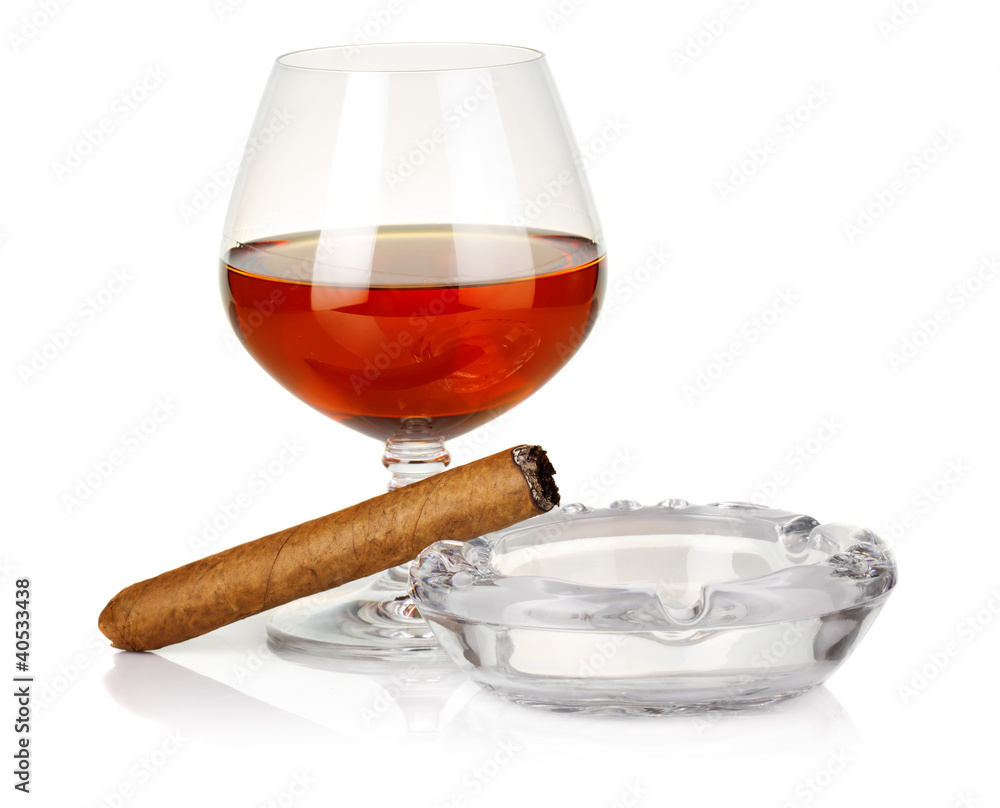 Cognac in glass with cigar and ashtray isolated