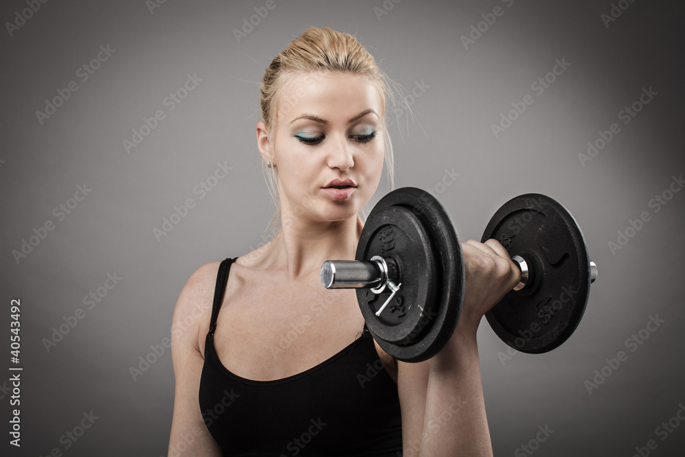 Obraz premium Athletic young lady working out with weights