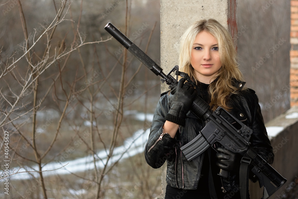 Fototapeta premium Scared girl with a rifle