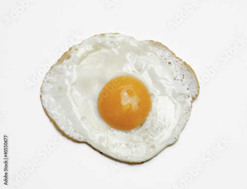 Un huevo frito en fondo blanco.