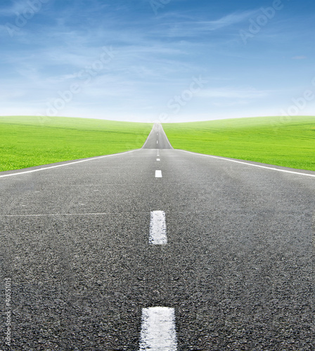 green field and road over blue sky