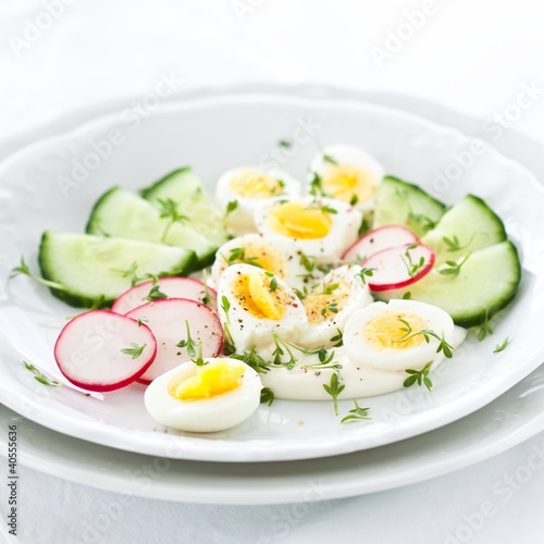 Quail eggs salad with cucumbers, radish and mayonnaise