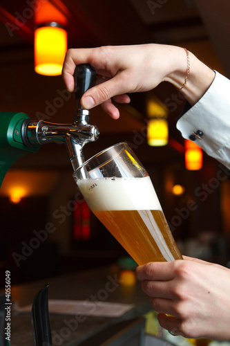 the bartender pours the beer