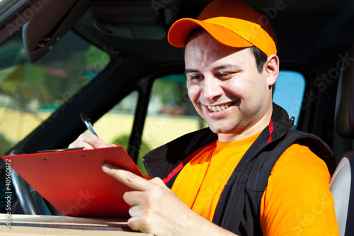 Delivery boy writing on clipboard