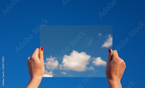 Hands holding a frame with clouds