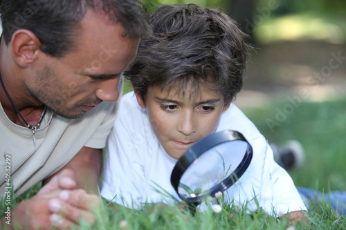 Foto father and kid with magnifying glass