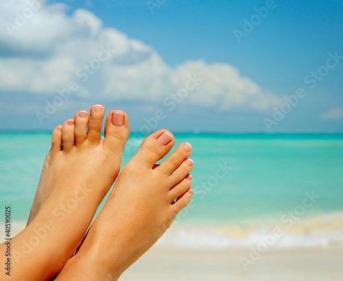 Vacation Concept. Woman's Bare Feet over Sea background