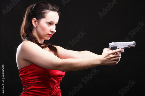 Sexy young woman - gun on black background