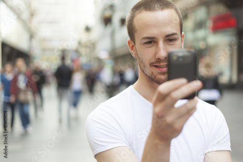 Young Man with cell phone walking